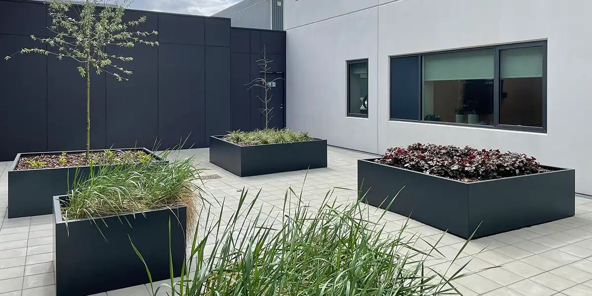 gårdhave med store krukker,